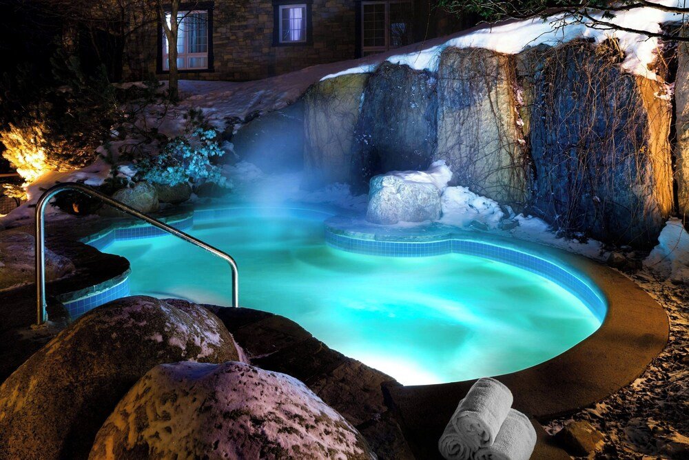 Hot spring style pool with a stone surround at Le Westin Tremblant